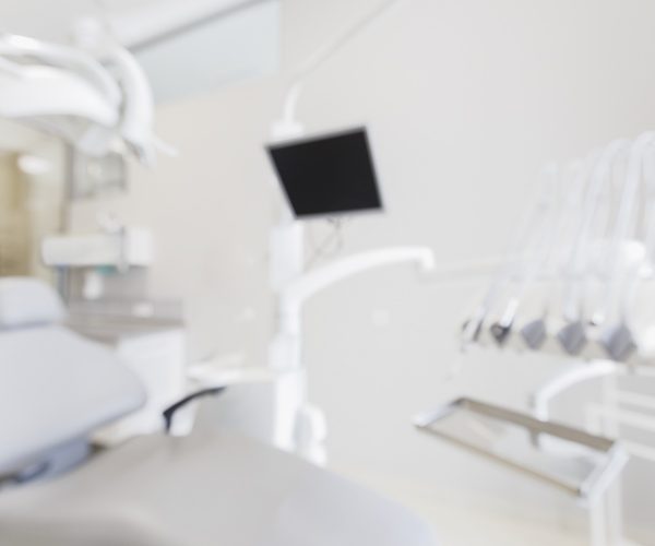 Blurred empty dentist workplace with professional equipment in white stomatologist office
